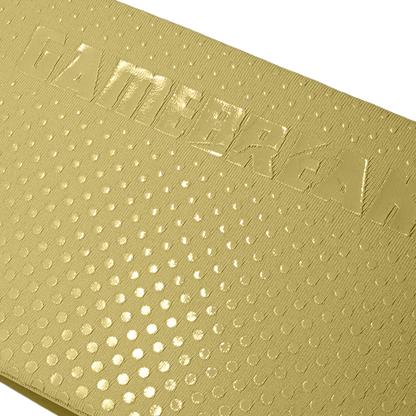 Close-up of a metallic gold textured surface with a repeating circular dot pattern and embossed lettering across the top.