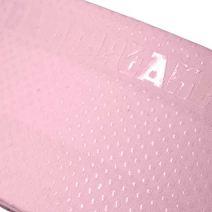 A close-up of a light pink textured material with a subtle embossed pattern and small reflective highlights, shown against a white background.