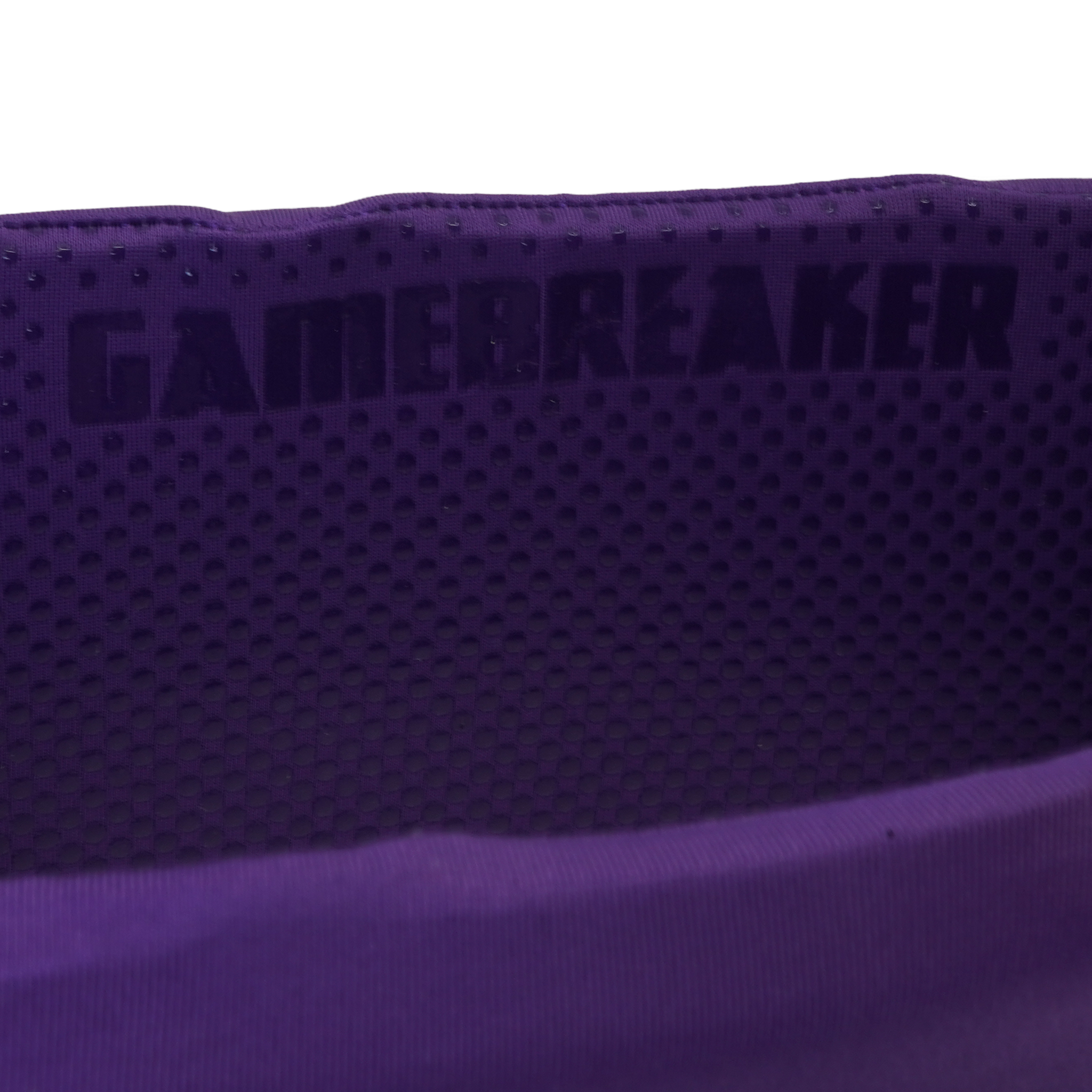 Close-up of a purple athletic headband with a perforated texture and the brand name 'GAMEBREAKER' printed in dark lettering.