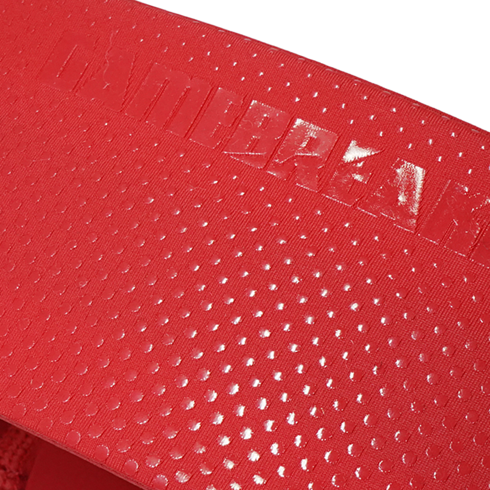 Close-up of a red textured surface with a repeating small dot pattern and a glossy embossed brand mark reading 'GAMEBREAKER' across the top.