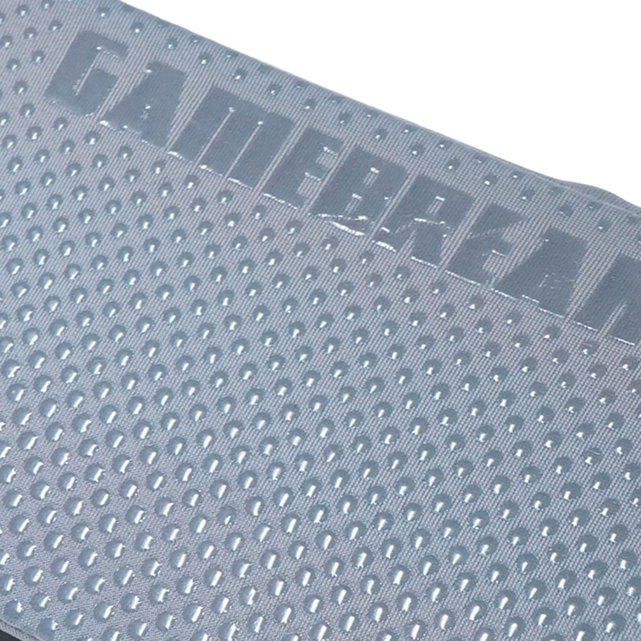 Close-up of a gray textured gaming mat with a raised 'GAMEBREAKER' logo and a uniform raised-dot pattern, shown against a white background.