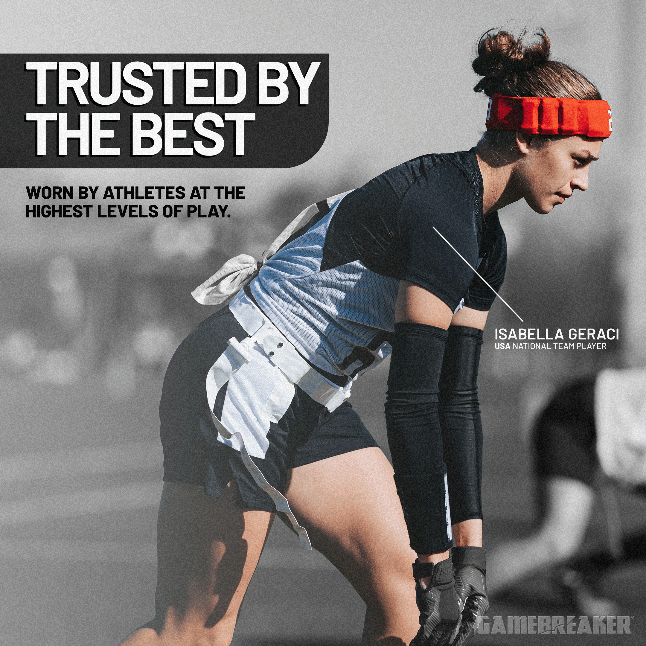 A focused female flag football player, Isabella Geraci (USA National Team Player), wears a red protective headband and athletic gear while crouched in a ready stance on the field. The image features bold text that reads "TRUSTED BY THE BEST" and "Worn by athletes at the highest levels of play." The GameBreaker logo is visible in the bottom right corner.